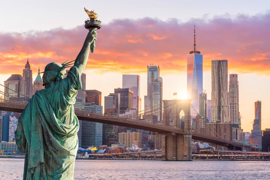 tatue Liberty and New York city skyline at sunset